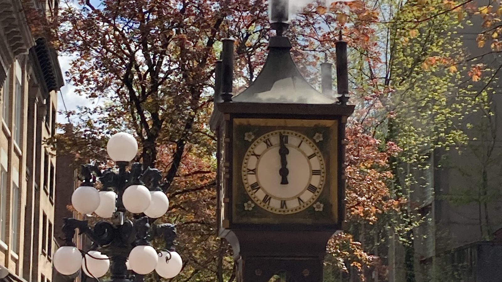 The Gastown steam clock in Vancouver, British Columbia, under autumn trees